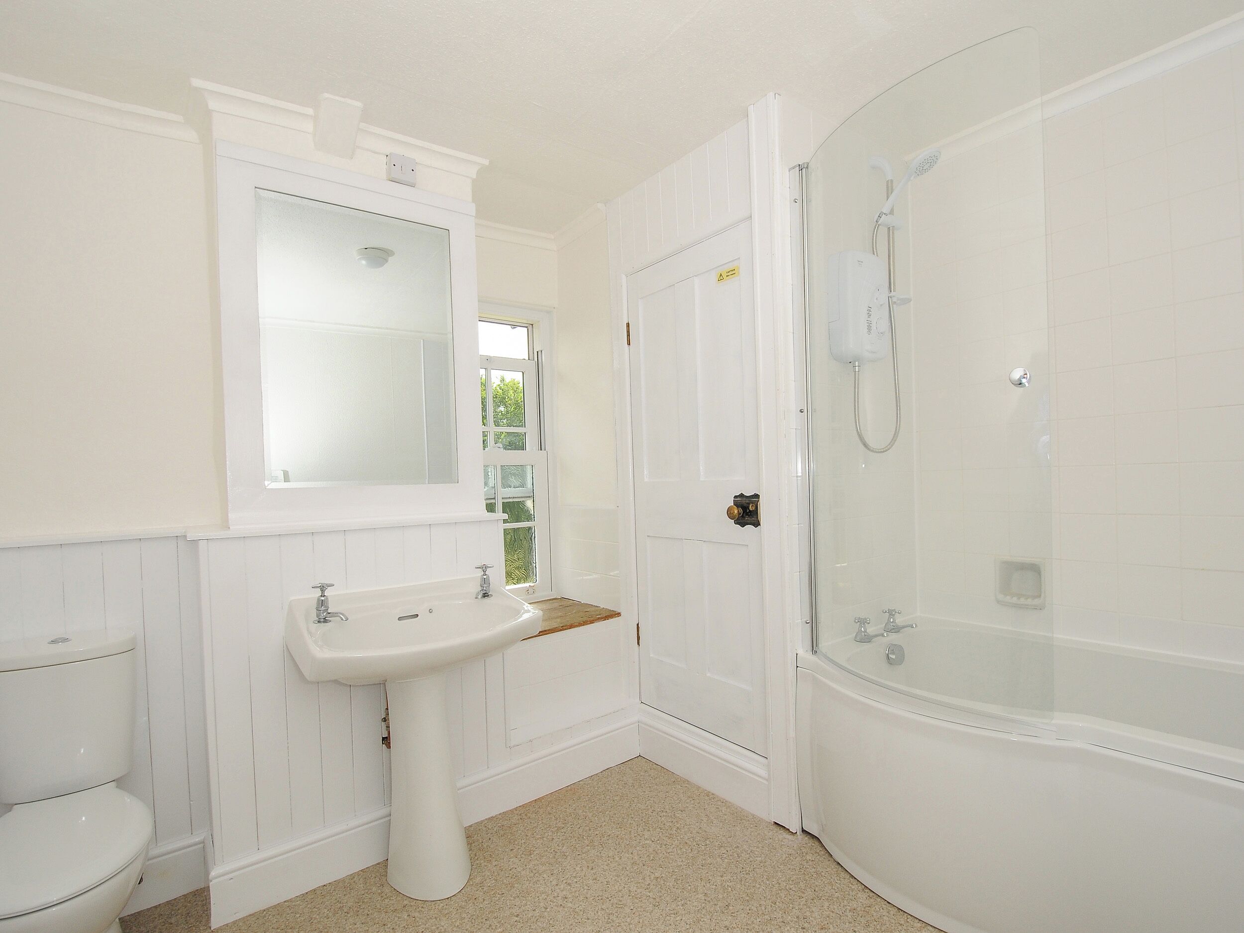 Un baño con lavamanos, inodoro y bañera blancos.