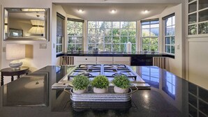 Una cocina moderna con una isla central, ventanas amplias y estufa integrada.
