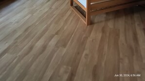 Ein geräumiges Wohnzimmer mit großem Fenster, Deckenventilator und Essbereich mit Tisch und Stühlen.