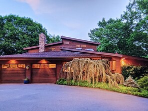 A modern house with a stone chimney, large windows, and a well-maintained garden. - TREETOPS! A Reunion/Retreat/Event estate! JULY OPENINGS Seasonal POOL! Sleeps 12 (Guilford)
