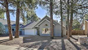 A residential house with a garage, surrounded by trees and a gravel driveway. - Modern Flagstaff Retreat ~ 4 Mi to Downtown! (Flagstaff)