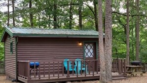 A small cabin with a porch, a window, and a door.