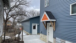 A residential area with houses, a concrete pathway, and a wooden bench. - Upscale King Suite—Steps from Mayo Clinic Hospital (Rochester)
