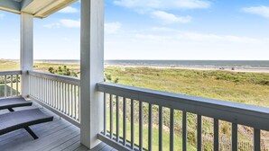 A covered porch with a view of the beach and ocean. - SEASHELLS BY THE SEASHORE - Beautiful beachfront, sleeps 12! (Port Bolivar)