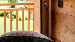 Interior de una cabaña de madera con ventana que da a una zona boscosa.