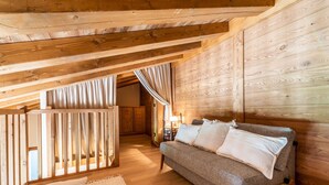 Interior acogedor de una cabaña de madera con un sofá y cortinas.