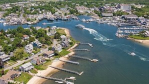 An aerial view of a coastal town with a marina, houses, and a beach. - The Breakwaters Hyannis - Your Home Away From Home! RPAM046 (Hyannis)