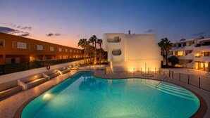 A swimming pool with steps leading into it, surrounded by a fence and palm trees. - Ocean View Apartment • Sunny Balcony • Near the Coast (Antigua)