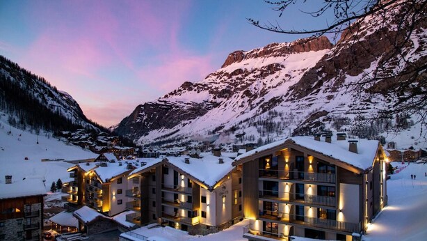 A snow-covered mountain lodge with multiple buildings, ski lifts, and a clear view of the surrounding mountains. - Wifi, ski-in/ski-out & foot of the slopes, fitness, swimming pool, sauna, hammam, balcony, tv (Val-d'Isère)
