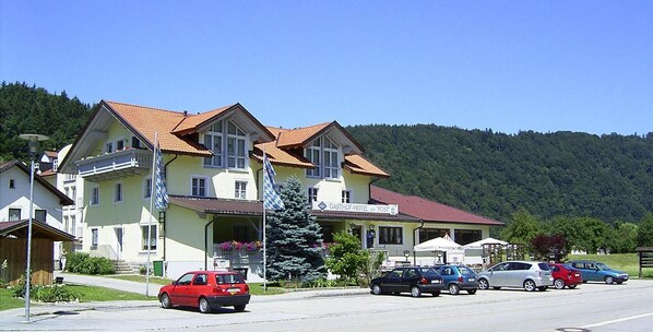 A hotel with a red roof, multiple windows, and a sign indicating it is a post hotel.