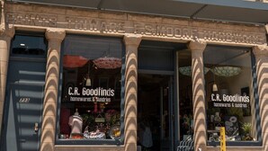 A historic building with storefronts labeled "C.R. Goodfinds homewares & sundries" and "PAINTS THINWARE F.S. MOUSE HARDWARE". - The Downtown Trifecta |Large & Unique Lodging | Perfect for Group Stays |Main St |Parking Included (Lake Geneva)