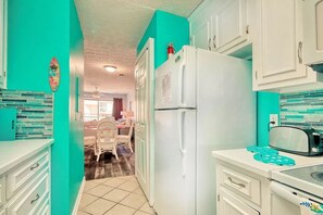 Compact kitchen with refrigerator, microwave, and dining area.