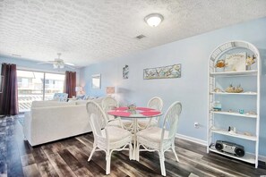 Relax in this stylish room with a round table, white chairs, and a comfortable sofa.