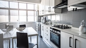 A modern kitchen with white cabinets, stainless steel appliances, and a large window providing natural light. - Sapphire Apartment, AC, Wifi !new! (Lisboa)