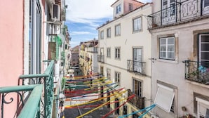 Una calle estrecha adornada con decoraciones coloridas colgadas entre edificios.