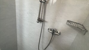 A shower with a handheld showerhead and a handheld hose.