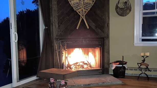 En stue med pejs, skydedør og et tæppe.