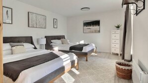 A bedroom with two beds, a white dresser, and a large window. - Unique & Sunny Top Floor Old Quebec Gem (Québec City)