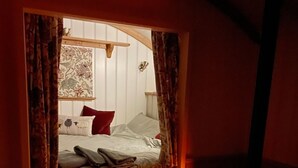 Una habitación acogedora con cama, ventana y chimenea.