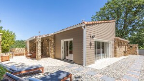 A modern outdoor patio with stone walls, a covered seating area, and a pool. - Villa La Roche Rouge (Pougnadoresse)
