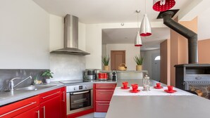 Una cocina moderna con armarios rojos, electrodomésticos de acero inoxidable y una isla central.