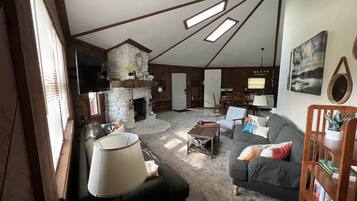 Télévision, cheminée, lecteur de DVD, livres