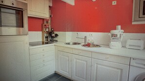 A kitchen with white cabinets, a sink, and a stove.