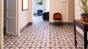 A hallway with patterned floor tiles, a chandelier, and a door leading to another room. - Capo 10 Liberty C3 - Two Bedroom Apartment, Sleeps 4 (Syracuse)