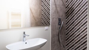 A bathroom with a white sink, a mirror, and a shower with a diagonal tile pattern. - Capo 10 Liberty C3 - Two Bedroom Apartment, Sleeps 4 (Syracuse)