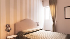 A bedroom with a bed, a nightstand, a wall-mounted lamp, and a window with curtains. - Capo 10 Liberty C3 - Two Bedroom Apartment, Sleeps 4 (Syracuse)