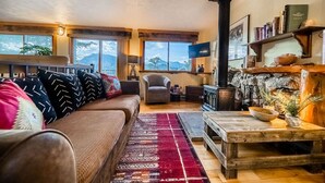 Un salon confortable avec un canapé, une cheminée et un téléviseur.