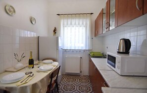 Enjoy meals at the dining table, equipped with plates, cutlery, and a bottle, and use the microwave for convenient cooking.