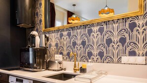 A compact kitchen with a washing machine, a coffee maker, and a toaster. - Studio lumineux et moderne proche du metro - 2P (Paris)
