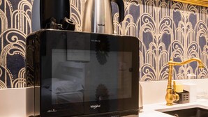 A Whirlpool microwave on a countertop with a sink and a dish rack. - Studio lumineux et moderne proche du metro - 2P (Paris)