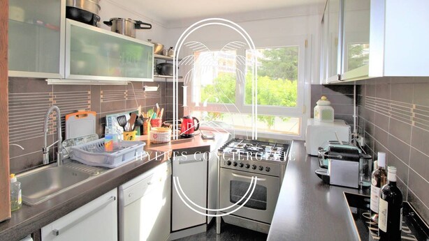 Eine moderne Küche mit Edelstahlgeräten, einem Fenster, das natürliches Licht hereinlässt, und Blick ins Grüne.