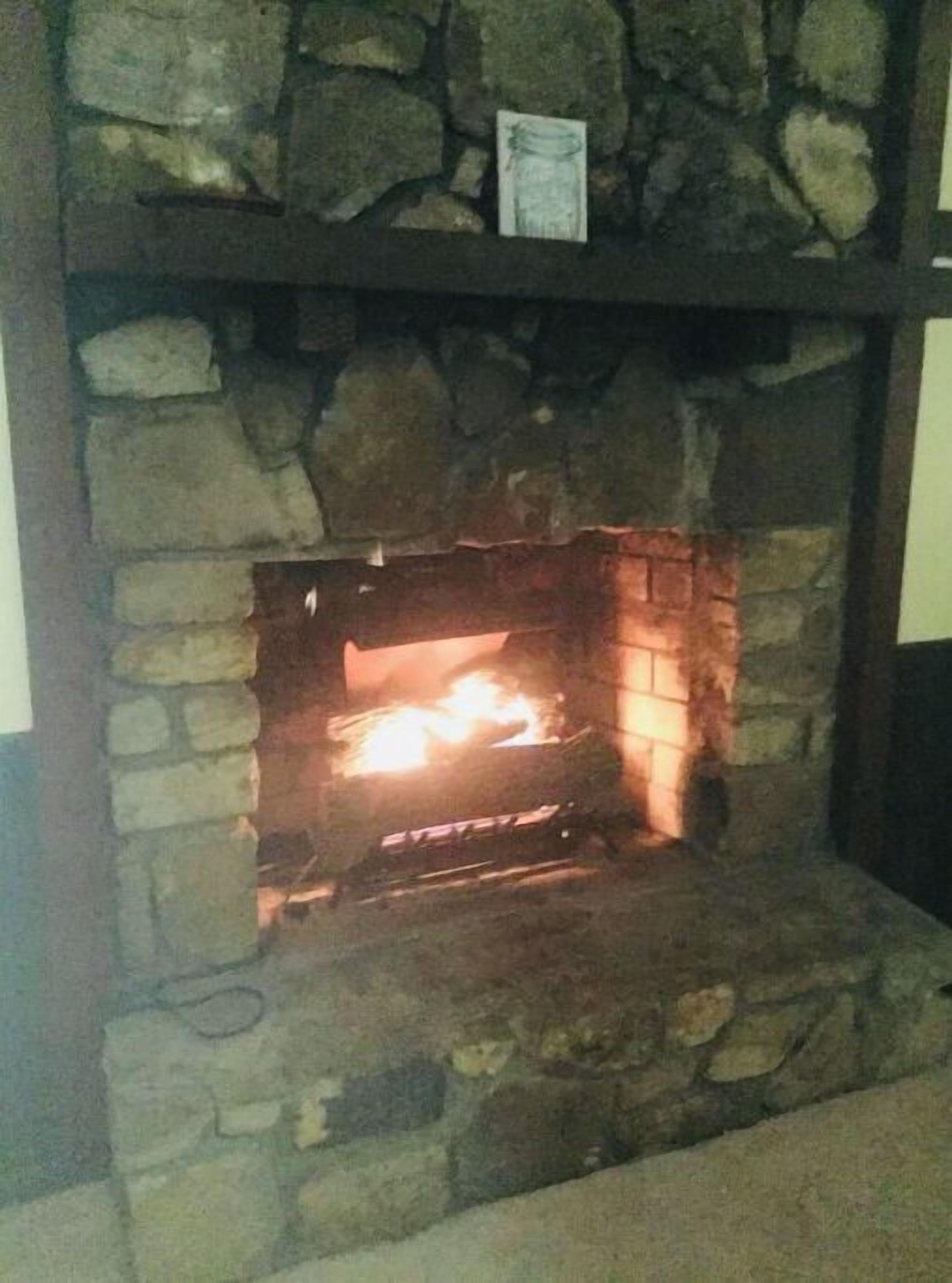 Una chimenea de piedra con fuego encendido.