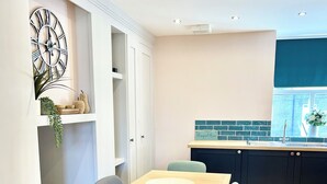 A modern kitchen with dark cabinets, a wooden countertop, and a window with a view. - Inviting Townhouse in Bedlington (Bedlington)