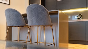 A modern bar area with two cushioned bar stools and a sleek bar counter. - No. 35 (York)