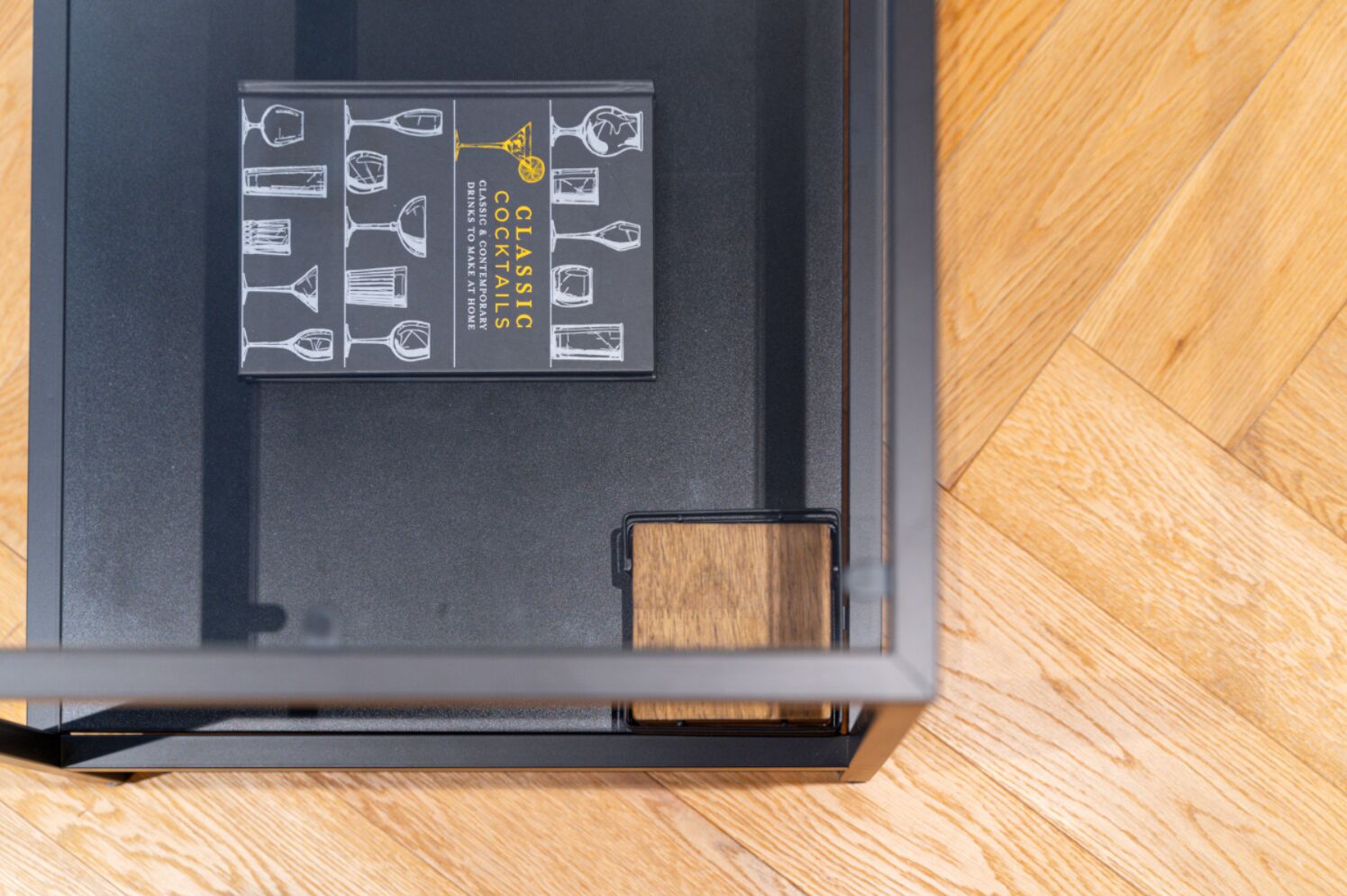 A black interior with a wooden floor and a black drawer with a wooden handle.