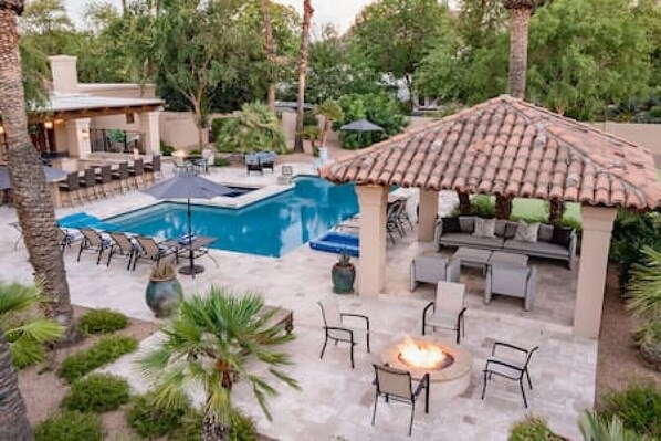A pool area with a fire pit and outdoor seating.
