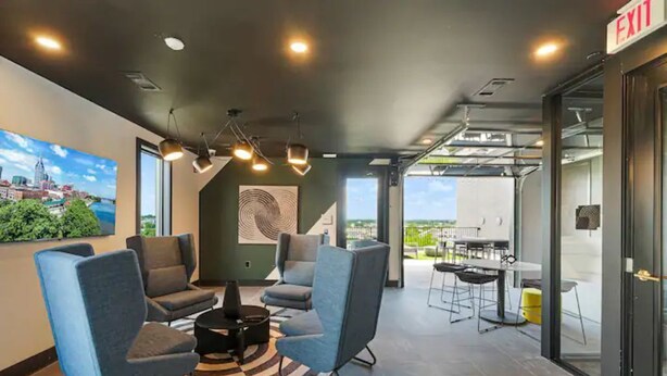 A modern lounge area with seating, a coffee table, and a view of the outdoors.