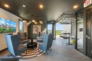 Un área de estar moderna con asientos, una mesa de centro y vistas al exterior.