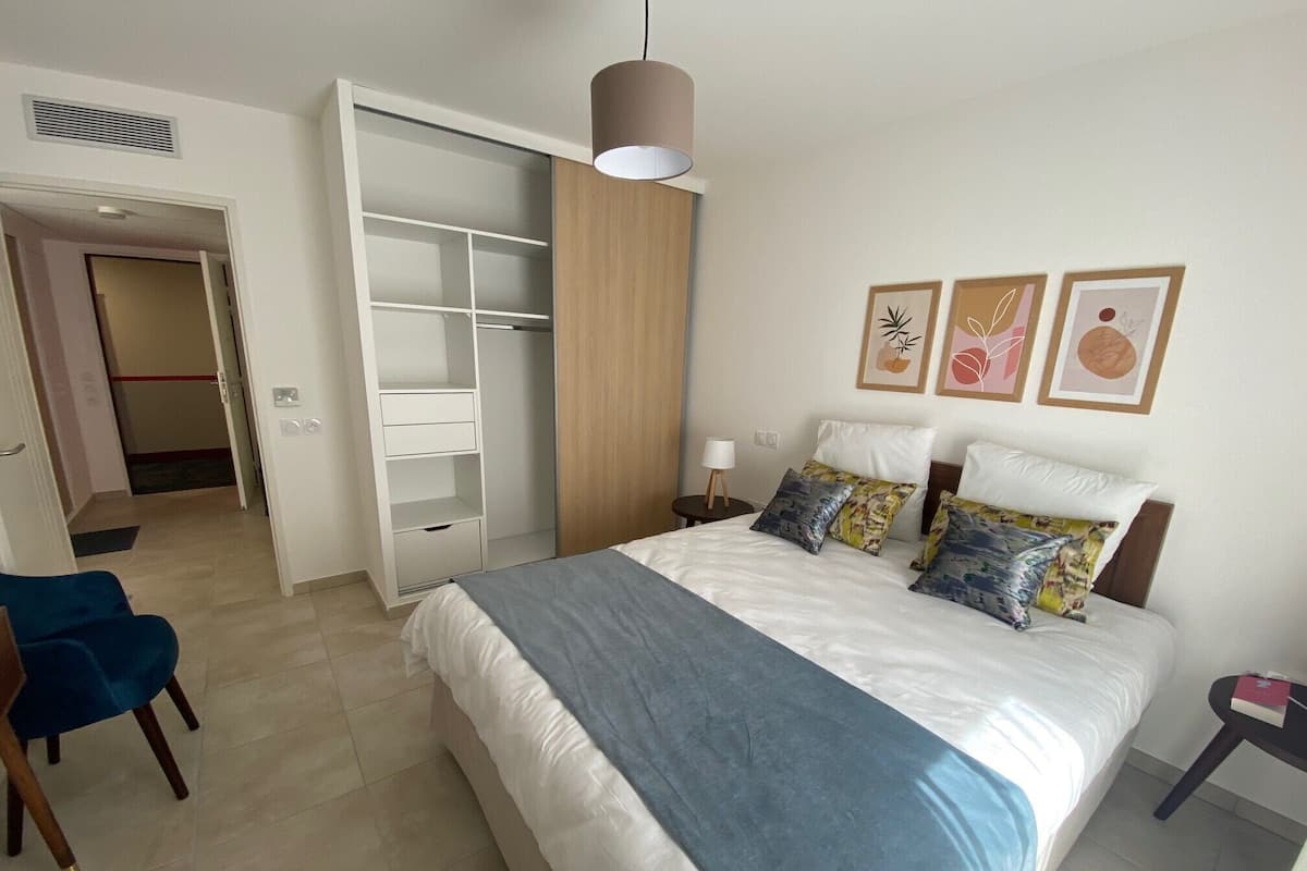 Una habitación de hotel con una cama, un armario, un escritorio y una silla.