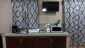 A kitchen with a microwave, toaster, and coffee maker on the counter. - Bungalows Victoria (La Manzanilla)
