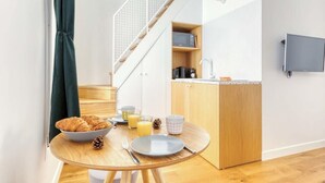 A compact kitchen with a dining area, a microwave, and a small sink. - Cute & Bright Studio in a Courtyard-Montmartre(5) (Paris)