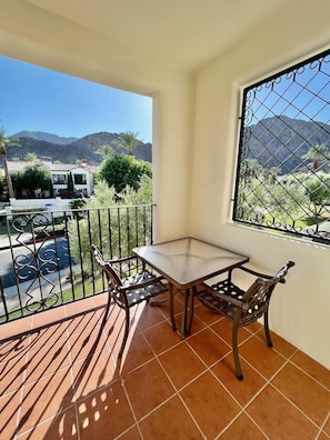 Enjoy a peaceful retreat on the balcony with a table for two and a view of the surrounding mountains.
