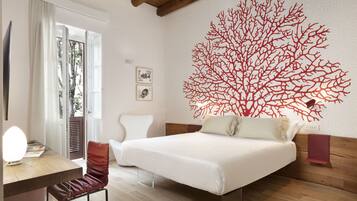 Un dormitorio con cama, escritorio, silla y una gran obra de arte en la pared.