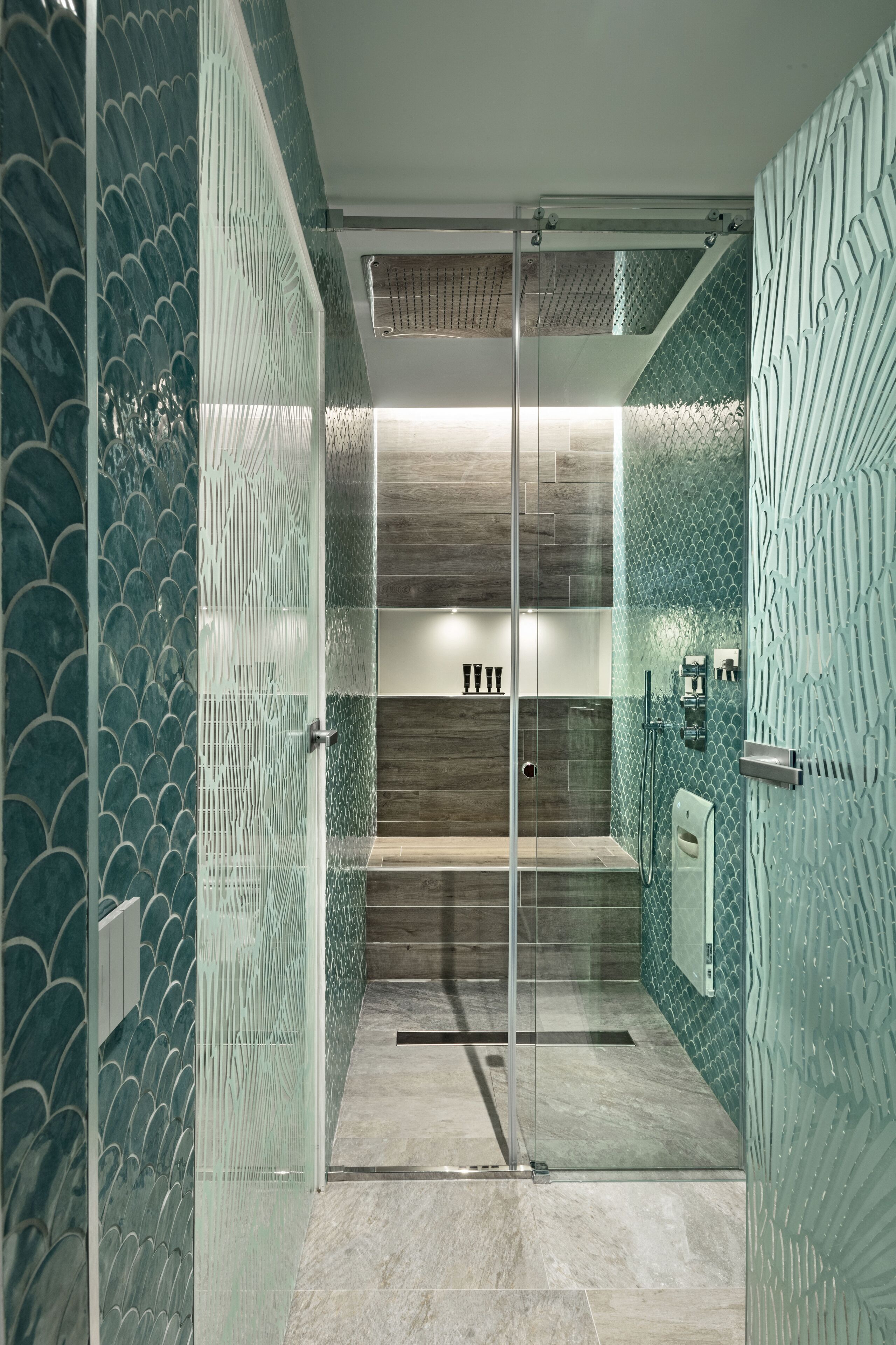 A modern bathroom with a glass shower enclosure, tiled walls, and a wooden vanity.