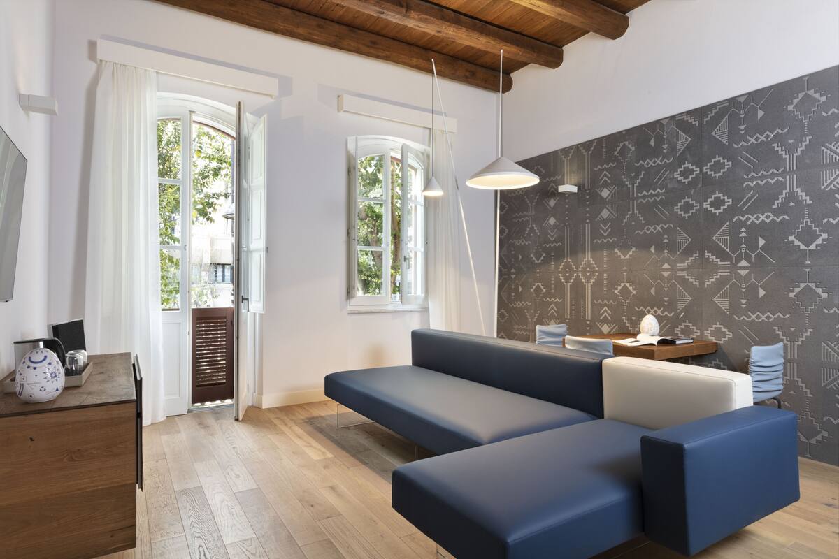 Ein modernes Wohnzimmer mit einer Couch, einem Holztisch und Wandpapier mit Muster.