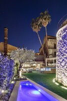 Una piscina al aire libre, sombrillas, sillones reclinables de piscina